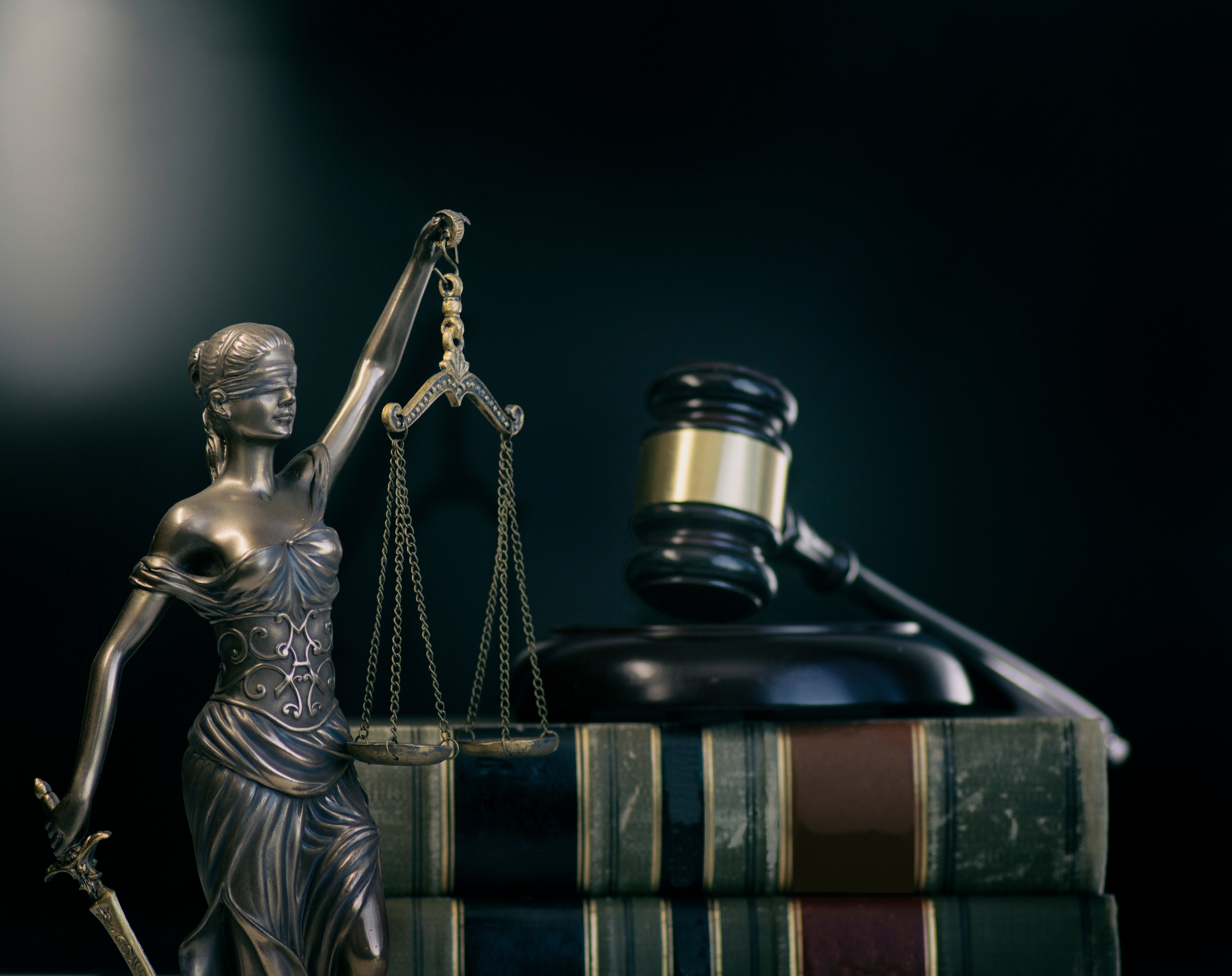 Lady Justice with sword, judge’s gavel, and law books